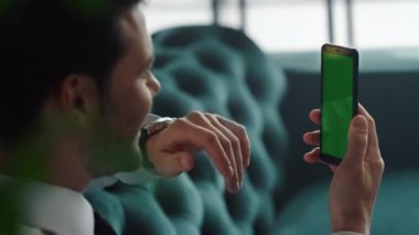 İş adamı akıllı telefondan video görüşmesi yapıyor. İçerde cep telefonu kullanan bir yönetici