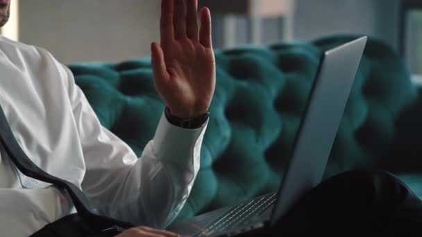 Unrecognizable businessman waving hand on laptop camera at remote workplace — Stock Video