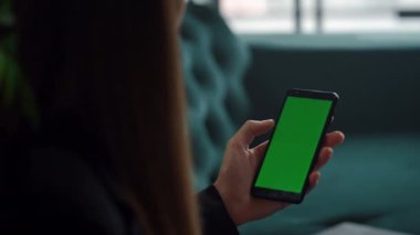Yeşil ekranlı akıllı telefon kullanan kadın elleri. Bilinmeyen kız telefonla çalışıyor.