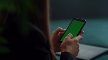 Yakından tanınmayan iş kadını yeşil ekranlı cep telefonuyla yazı yazıyor.