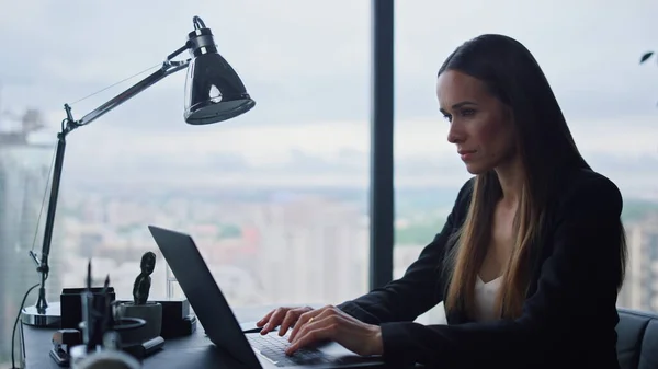 Empresaria trabajando en el portátil en la oficina. Mujer seria escribiendo en el teclado —  Fotos de Stock