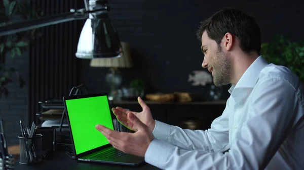 Empresário positivo vídeo bate-papo on-line no laptop com tela verde no escritório — Fotografia de Stock