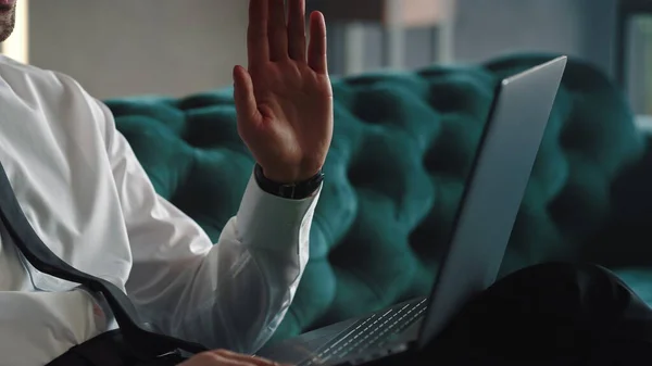 Homme d'affaires méconnaissable agitant la main sur une caméra d'ordinateur portable sur un lieu de travail distant — Photo