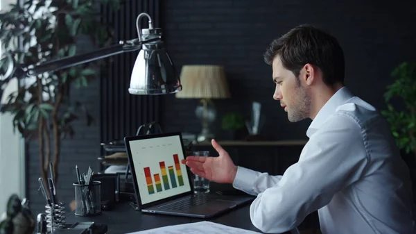 Homme d'affaires analysant des graphiques sur écran d'ordinateur portable au bureau. Homme travaillant sur ordinateur portable — Photo