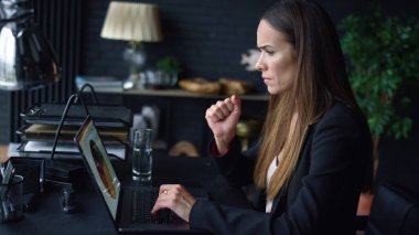 İş kadını ekranda grafikleri analiz ediyor. Laptop klavyesinde yazan kadın