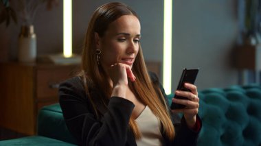 Modern iç mekanlarda akıllı telefon kullanan bir iş kadını. Telefondaki profesyonel mesajlaşma