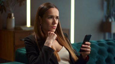 Modern iç mekanlarda akıllı telefon kullanan bir iş kadını. İşçi cep telefonuna bakıyor