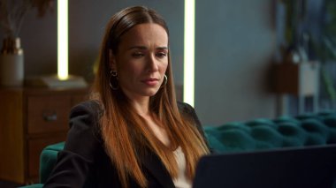 İş kadını portresi. Dizüstü bilgisayarda çalışan üzgün iş kadını