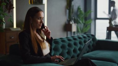 Akıllı telefondan konuşan kendine güvenen bir iş kadını. İşadamı ofiste yürüyor.