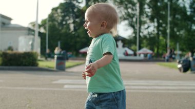Gülen çocuk lunaparkta koşuyor. Sevimli çocuk annesine sarılıyor.