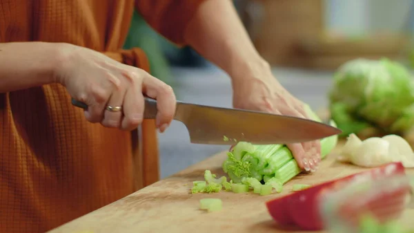 Mulher mãos cortando aipo na tábua de corte. Dona de casa cozinhar legumes frescos — Fotografia de Stock