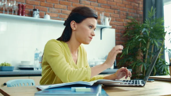 Деловая женщина работает дома над ноутбуком. Раздражённая девушка делает перерыв на кухне. — стоковое фото