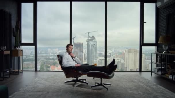 Бизнесмен отдыхает в офисном кресле. Уставший работник настраивает галстук в офисе — стоковое видео