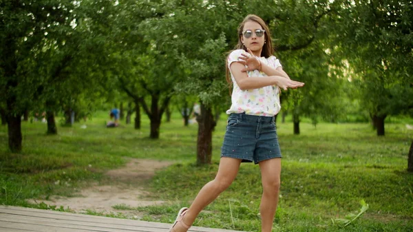 Lustige Mädchen tanzen im Freien. Konzentriertes Teenie-Mädchen macht rhythmische Bewegungen. — Stockfoto