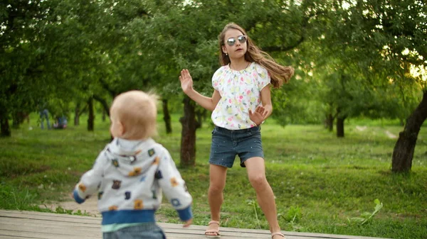 Söta barn som gör rytmiska rörelser utomhus. Broder och syster dansar — Stockfoto