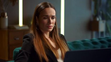 İş kadını portresi. Dizüstü bilgisayarda çalışan üzgün iş kadını