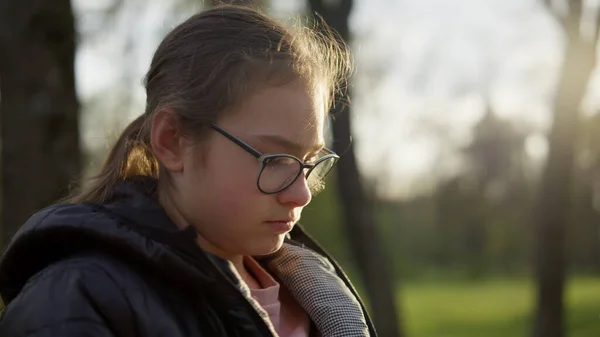 Jolie fille assise dans un parc ensoleillé. adolescent fille lecture à l'extérieur — Photo