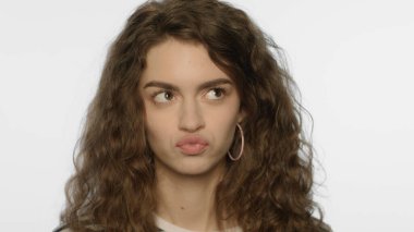 Stüdyoda dudak büken kaprisli bir kadın. Kafası karışmış kızın portresi