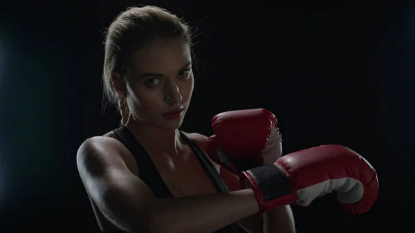 Mujer luchadora preparándose para el entrenamiento deportivo en el gimnasio oscuro. Retrato de mujer boxeadora — Foto de Stock