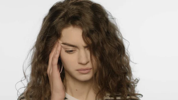 Dolor de cabeza de mujer cansada. Retrato de chica molesta tocando la cabeza con la mano en el estudio — Foto de Stock