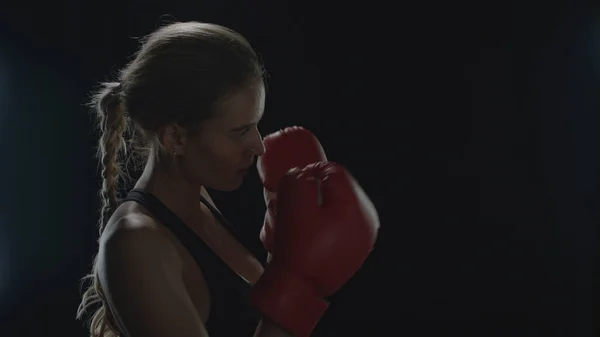 Mujer boxeadora pateando aire en cámara lenta. Mujer luchadora entrenamiento ponche — Foto de Stock