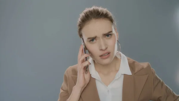 Wściekła bizneswoman dzwoniąca na komórkę w studio. Wściekła bizneswoman — Zdjęcie stockowe