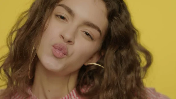 Jonge vrouw zoenen lippen met citroen plakjes in de voorkant van de ogen — Stockfoto