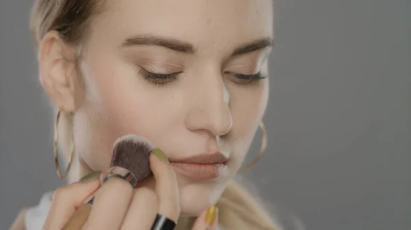 Stüdyoda makyaj fırçalı manken yüzü. Genç kadın makyajla yüz yüze — Stok fotoğraf