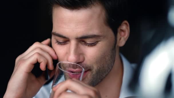 Empresario cara llamando en el teléfono inteligente en la oficina. Hombre beber agua de vidrio — Vídeos de Stock