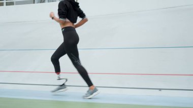 Koşu parkurunda koşan engelli kadın. Spor caddesinde koşan atlet bacakları