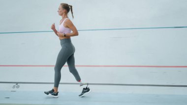 Stadyumda koşan engelli bir sporcu. Spor pistinde koşan kadın koşucu