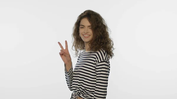 Uśmiechnięta kobieta pokazuje znak V na białym tle. Pozytywna dziewczyna pokazać v gest — Zdjęcie stockowe