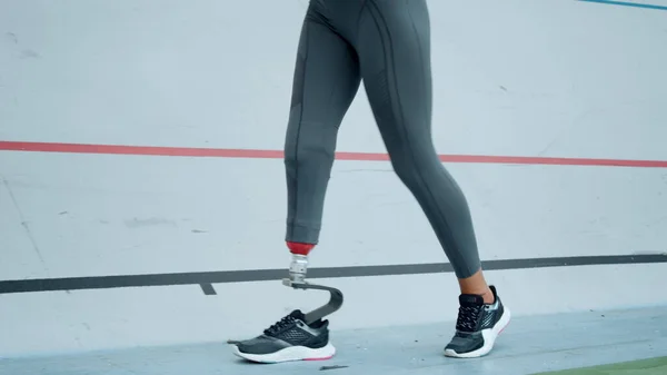 Fogyatékos nő elkezdett futni a stadionban. Sportnő lábak edzés szabadban — Stock Fotó