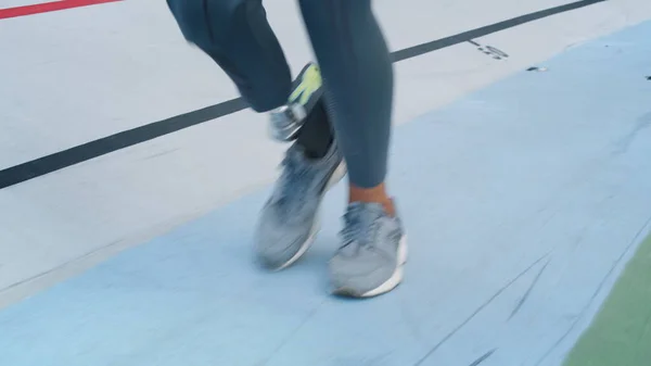 Een vrouw met een kunstbeen op de rails. Sportspersoon oefenen in het stadion — Stockfoto