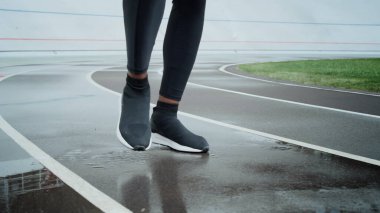 Sportif adam bacaklarını ısıtıyor. Sporcu ayakları stadyumda koşuyor.