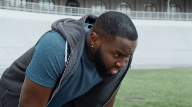 Koşu üstüne koşu yapmaktan yorgun bir sporcu. Antrenmandan sonra dinlenen bir adam.