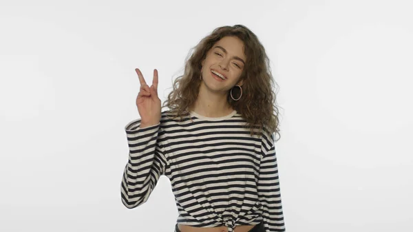 Young woman showing v sign in studio. Winner girl showing victory sign — Stock Photo, Image