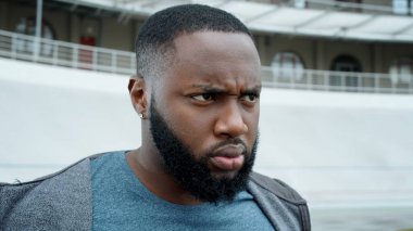 Spor giyim sektöründe odaklanmış bir adam doğru yolda duruyor. Ciddi bir adam dışarı bakıyor.