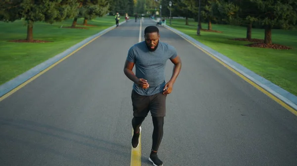 Biegacz zaczyna biegać w parku. Skoncentrowany sportowiec jogging na świeżym powietrzu — Zdjęcie stockowe