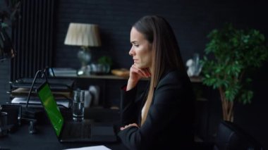 İş kadını videosu internette, ofiste yeşil ekranla sohbet ediyor.