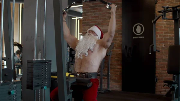 Güçlü Noel Baba spor salonunda göğüs presi yapıyor. Spor kulübünde sporcu eğitimi. — Stok fotoğraf