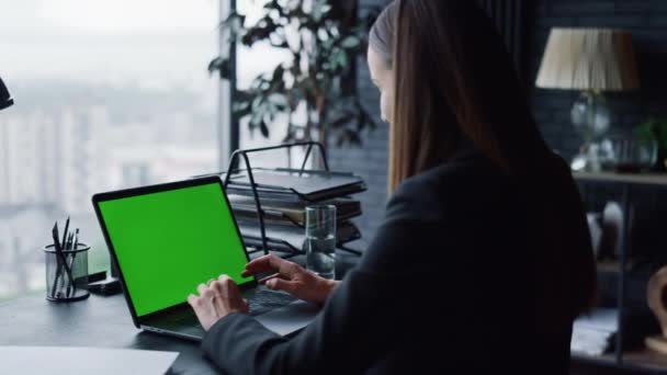 Впевнена бізнес-леді, що має відеодзвінок на ноутбуці з зеленим екраном в офісі — стокове відео