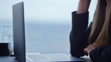 İş yerinde dizüstü bilgisayarla oturan bir iş kadını. El ele tutuşan kadın