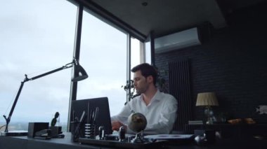 Ofiste dizüstü bilgisayarla çalışan bir iş adamı. Telefonla cevap veren işçiler