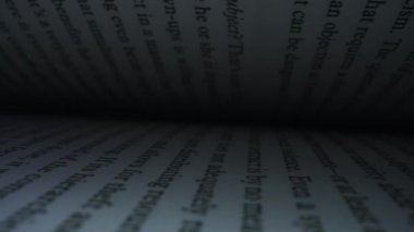 Beyaz sayfalı açık bir kitap. Açık kitabın kitap sayfaları arasında hareket eden kamera.