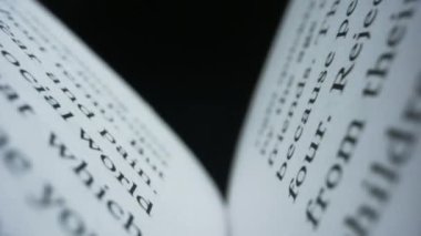 Siyah arka planda beyaz sayfaları olan açık bir kitap. Kapalı Kitabı Kapat