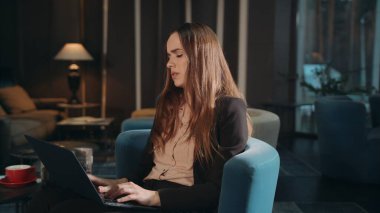 Gece otel lobisinde dizüstü bilgisayarda çalışan bitkin bir kadın. Yorgun iş kadını.