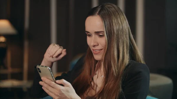 Leende kvinna gör videosamtal på mobiltelefon i vardagsrummet — Stockfoto