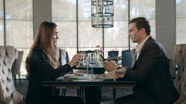 Restoranda cep telefonu kullanan iş adamları. İş çifti telefonları çalışıyor