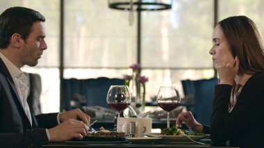 Restoranda yemek yiyen iş çifti. Kadın ve erkek kafede şarap içiyor.